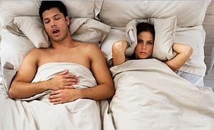 women covering ear with pillow